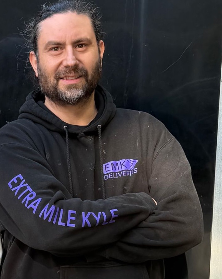 Kyle Haskell, owner of EMK Deliveries, in an Extra Mile Kyle hoodie